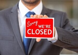 Man holding up we're closed sign