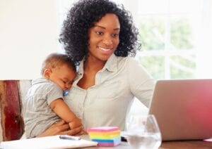 Mum working on a laptop holding a baby